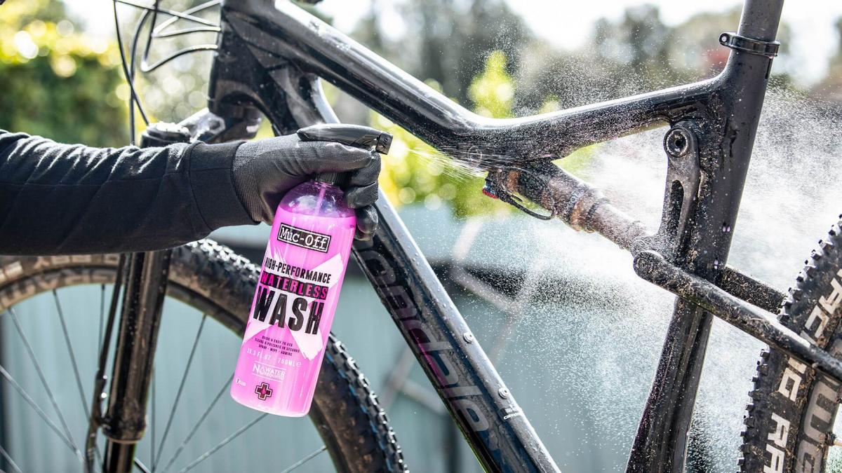 Muc-Off High Performance Waterless Wash 750ml appliceras på en mountainbike för effektiv rengöring utan vatten.